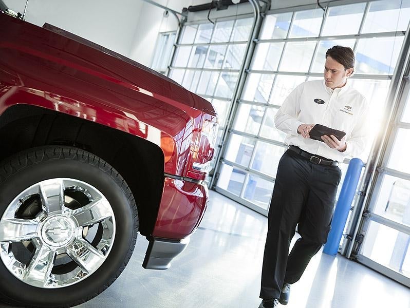 Service technician inspecting a truck at Tradition Chevrolet in Geneva NY